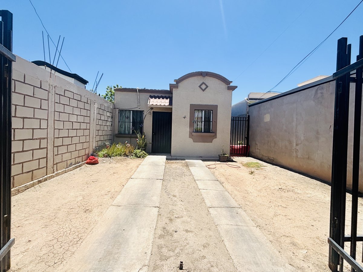 Entrada a la casa con la reja abierta